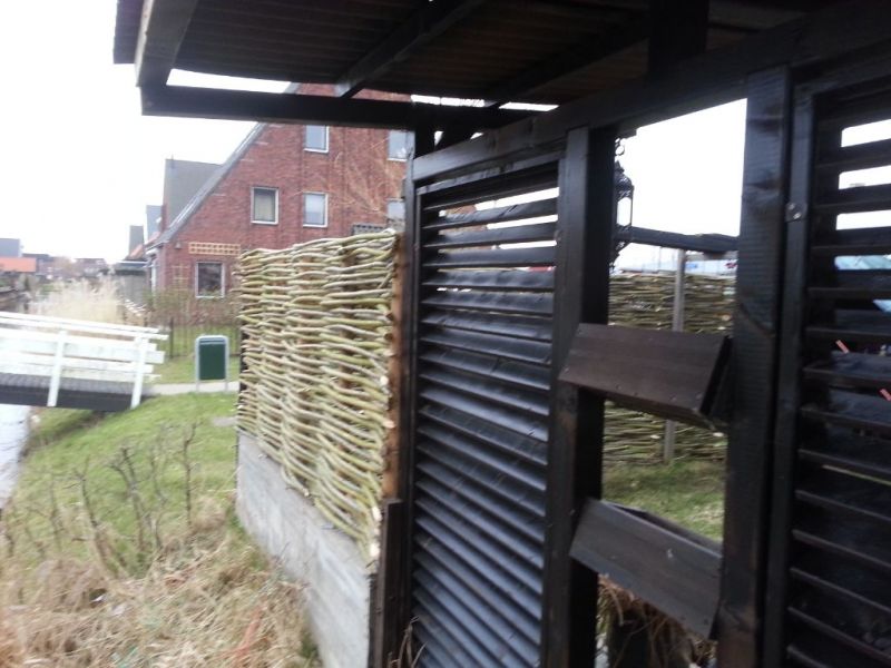 Wilgentenen gecombineerd met zwarte planken schutting